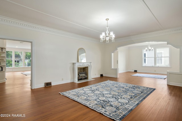 living room with an inviting chandelier, crown molding, and wood-type flooring