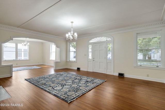 foyer entrance with an inviting chandelier, plenty of natural light, and hardwood / wood-style flooring