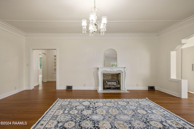 unfurnished living room featuring an inviting chandelier, a fireplace, and dark hardwood / wood-style flooring