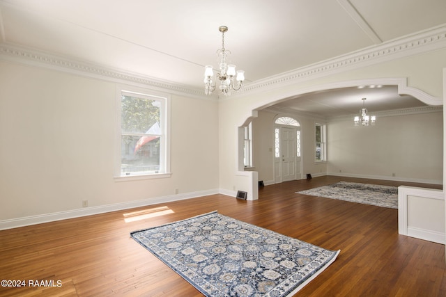 foyer entrance with an inviting chandelier, crown molding, and hardwood / wood-style flooring