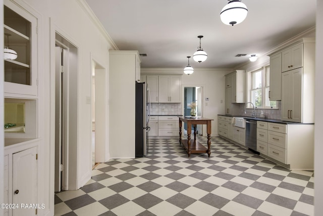 kitchen with ornamental molding, appliances with stainless steel finishes, pendant lighting, and decorative backsplash