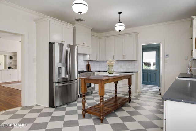 kitchen featuring pendant lighting, stainless steel appliances, crown molding, and white cabinets