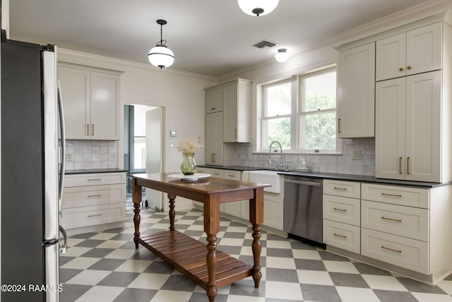 kitchen with sink, decorative light fixtures, ornamental molding, stainless steel appliances, and decorative backsplash