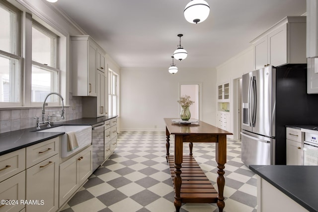 kitchen with white cabinetry, sink, decorative light fixtures, and appliances with stainless steel finishes