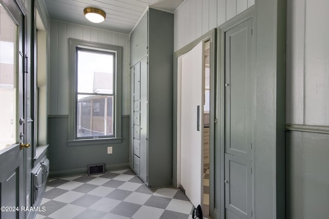 doorway to outside with wooden walls