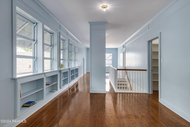 corridor with dark wood-type flooring and ornamental molding