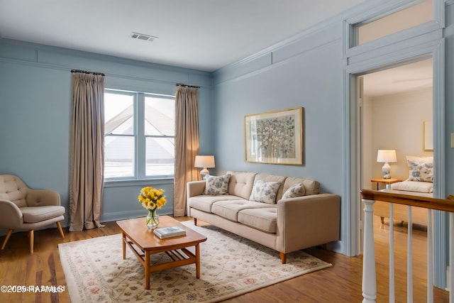 living room with hardwood / wood-style flooring and ornamental molding