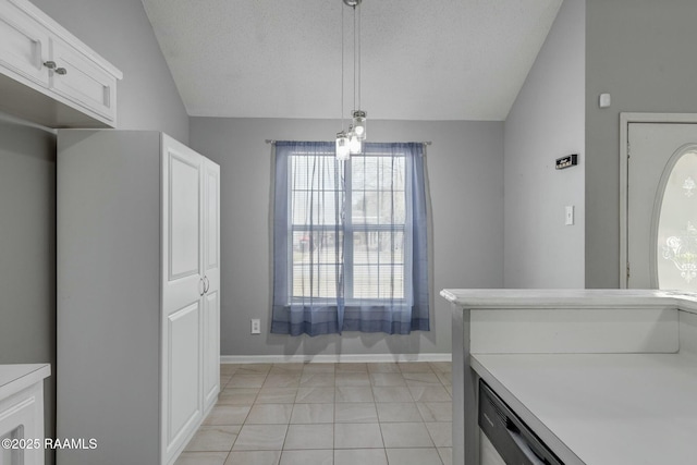 kitchen with white cabinetry, lofted ceiling, a textured ceiling, and decorative light fixtures