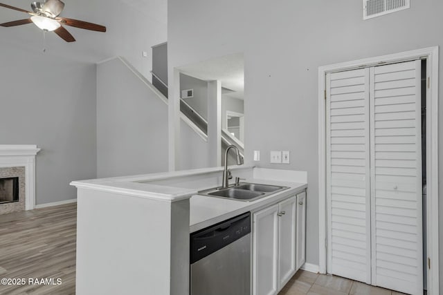 kitchen with sink, ceiling fan, white cabinetry, light hardwood / wood-style floors, and stainless steel dishwasher