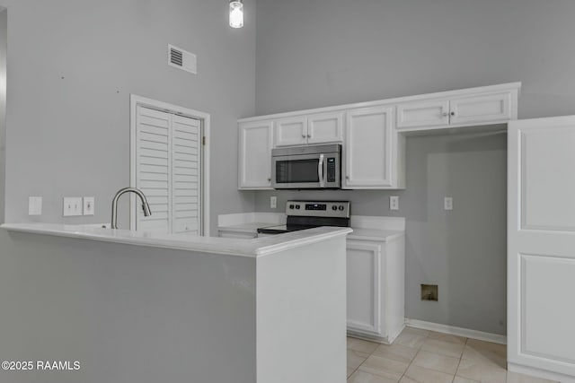 kitchen with stainless steel appliances, white cabinetry, sink, and kitchen peninsula