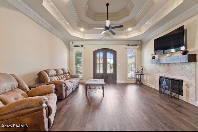 living room featuring dark hardwood / wood-style floors, a wealth of natural light, french doors, and a raised ceiling