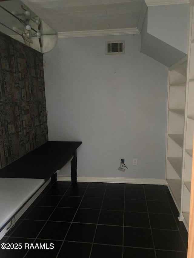 interior space featuring ornamental molding and dark tile patterned flooring