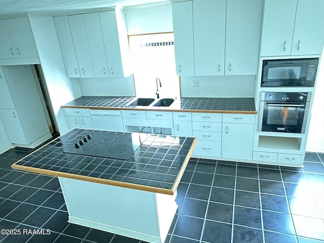 kitchen featuring white cabinets, tile countertops, and black appliances