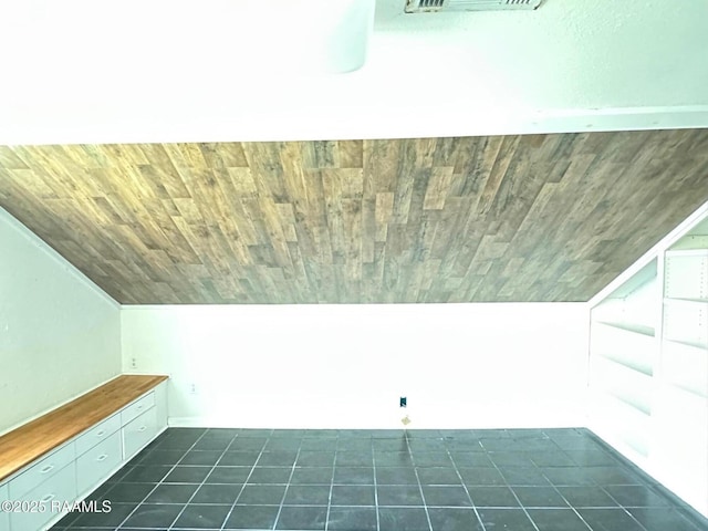 bonus room with vaulted ceiling, dark tile patterned flooring, and wood ceiling