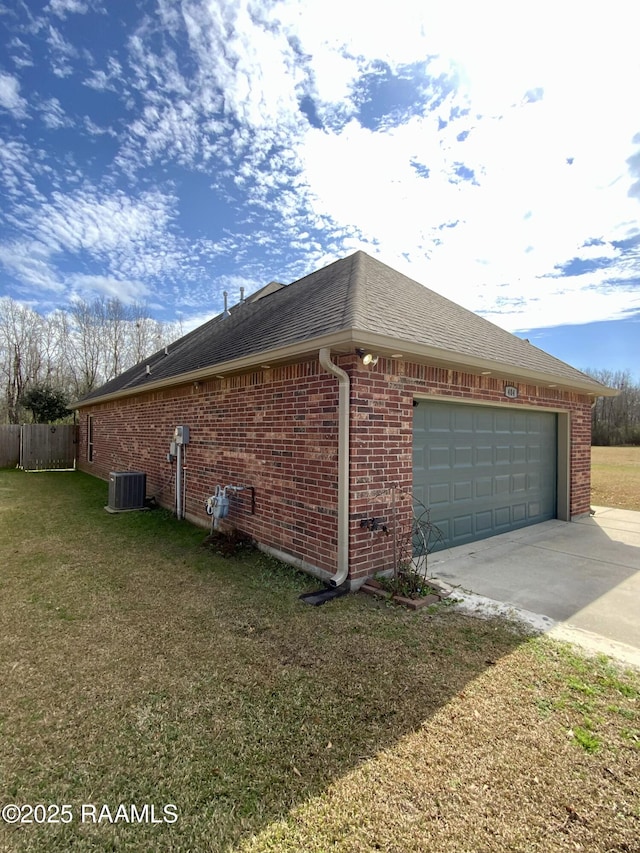 view of side of home featuring cooling unit, a garage, and a lawn