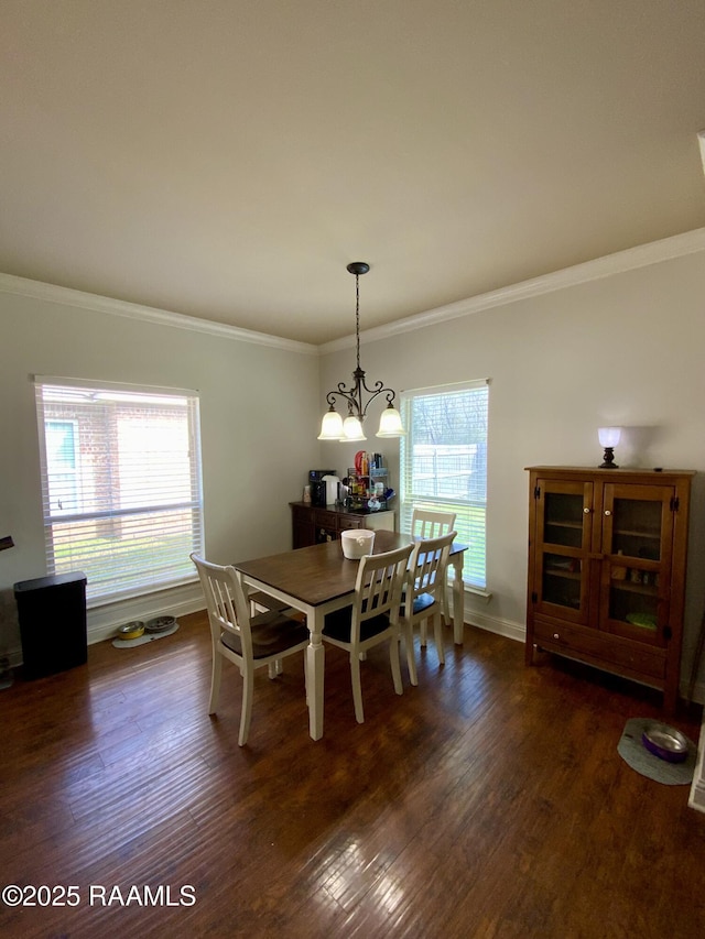 dining space with dark wood-type flooring, crown molding, and a chandelier