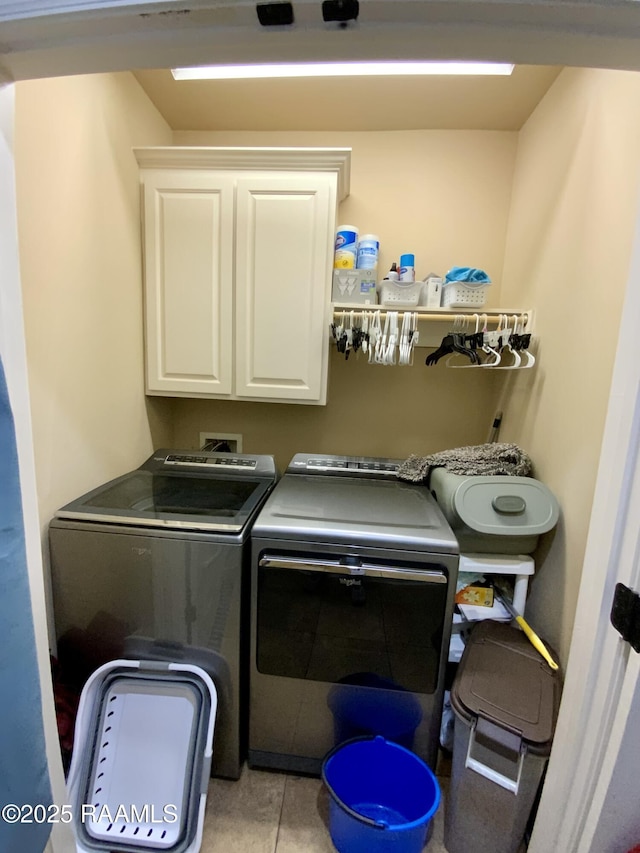 washroom with cabinets, washer and clothes dryer, and light tile patterned floors