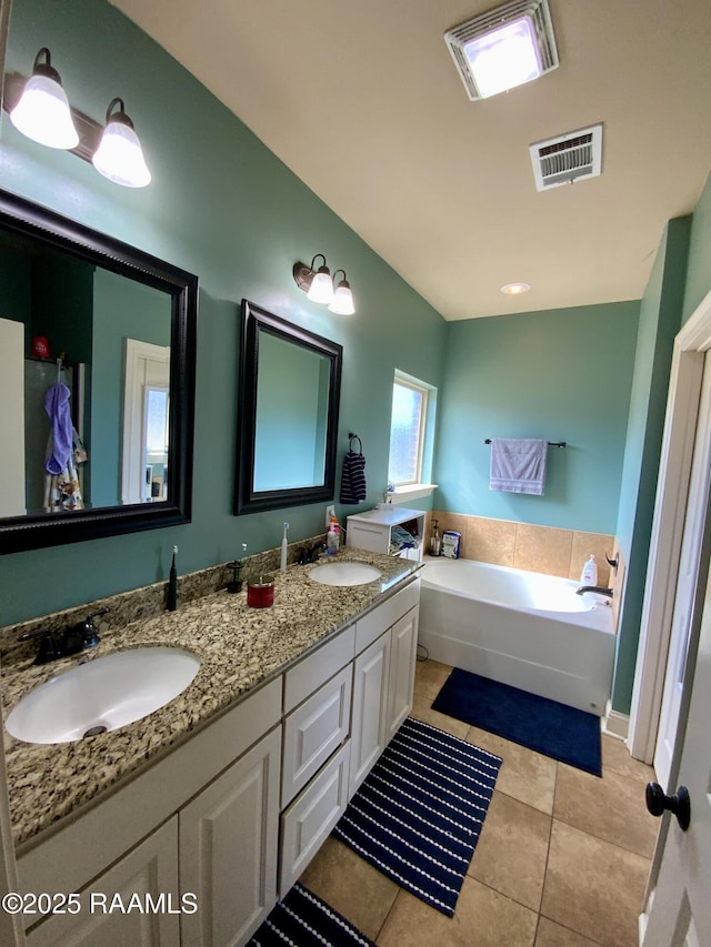 bathroom featuring vanity, a bathtub, and tile patterned floors