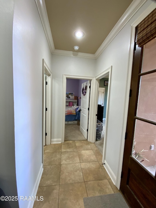 hallway with ornamental molding and light tile patterned floors