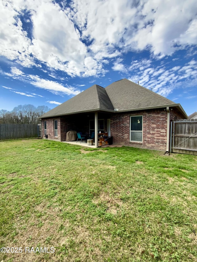 rear view of property with a yard and a patio area