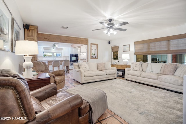 tiled living room with ceiling fan