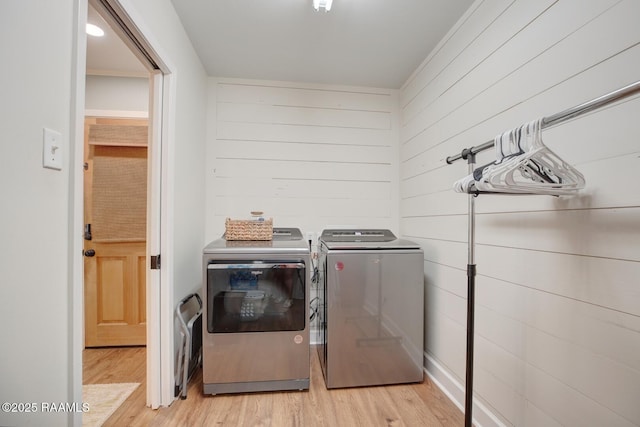 laundry room featuring washer and clothes dryer and light hardwood / wood-style flooring