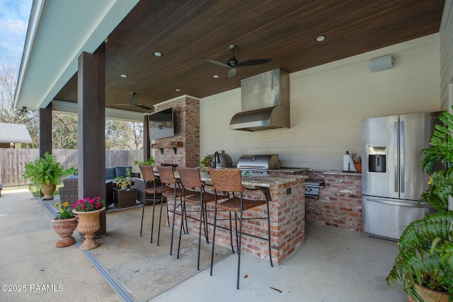 view of patio featuring a bar, area for grilling, and ceiling fan