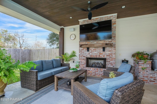 view of patio / terrace featuring ceiling fan and an outdoor living space with a fireplace