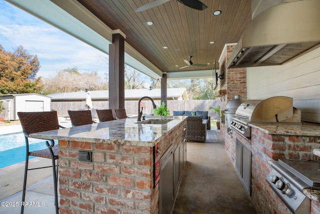 view of patio / terrace featuring area for grilling, a wet bar, and ceiling fan