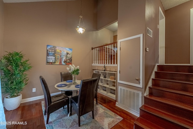 dining room with dark hardwood / wood-style floors and a high ceiling