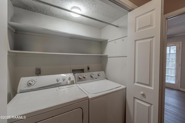 laundry area featuring wood-type flooring, washer and clothes dryer, and a textured ceiling