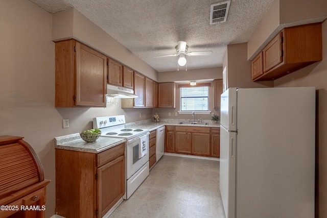 kitchen featuring sink, white appliances, a textured ceiling, and ceiling fan