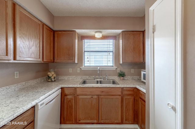 kitchen featuring sink, white appliances, and a textured ceiling