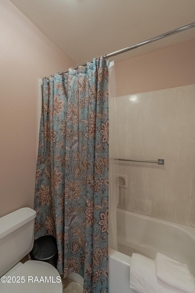 bathroom featuring toilet and shower / bath combo with shower curtain