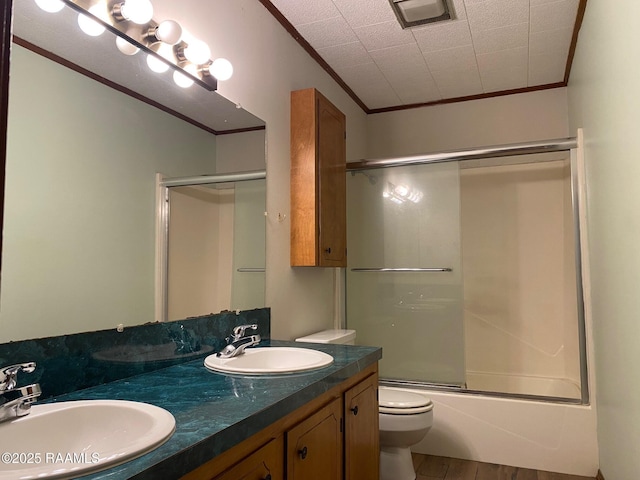 full bathroom with vanity, hardwood / wood-style floors, crown molding, and enclosed tub / shower combo