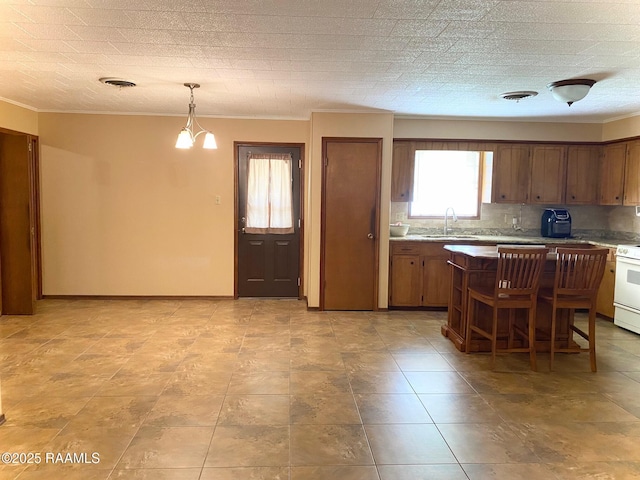 kitchen featuring visible vents, a kitchen island, a chandelier, light countertops, and a sink