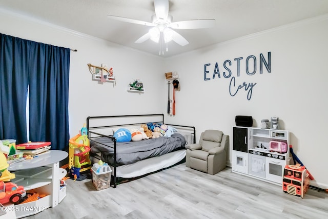 bedroom featuring ceiling fan, ornamental molding, and light hardwood / wood-style flooring