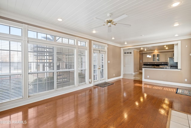 unfurnished living room with ornamental molding, wood-type flooring, wood ceiling, and ceiling fan