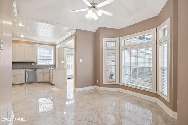 kitchen with sink, a wealth of natural light, stainless steel dishwasher, and ornamental molding