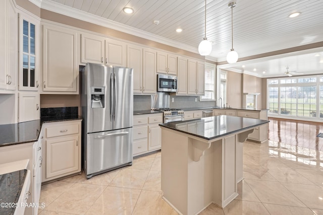 kitchen featuring a kitchen island, appliances with stainless steel finishes, pendant lighting, light tile patterned floors, and crown molding