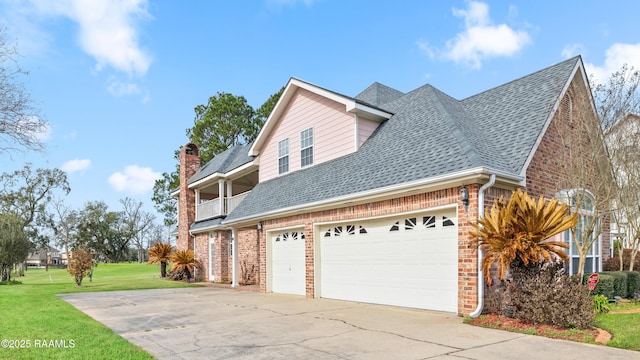 view of home's exterior featuring a balcony, a garage, and a lawn