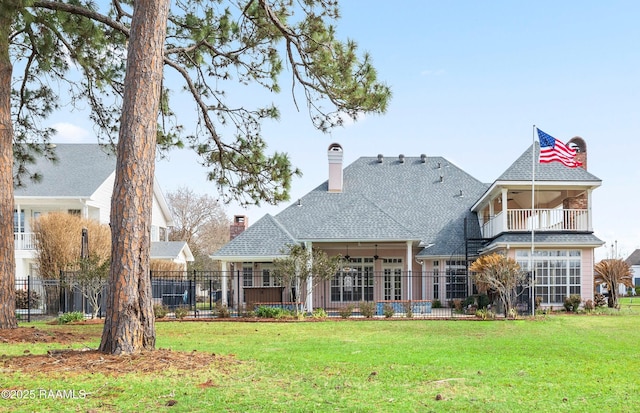 back of property featuring a balcony and a yard