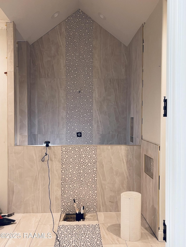 bathroom featuring tile walls and lofted ceiling