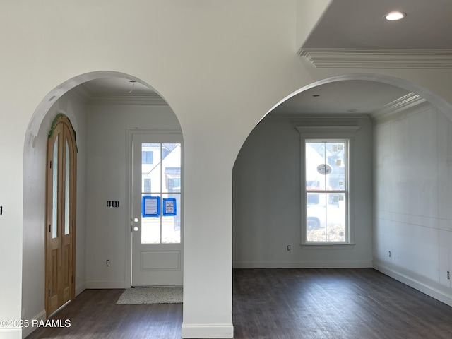 foyer entrance with ornamental molding and dark hardwood / wood-style flooring