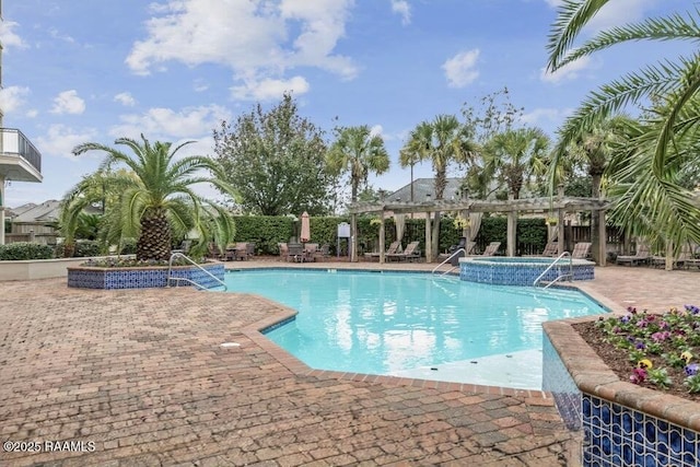 view of swimming pool featuring a pergola, a hot tub, and a patio