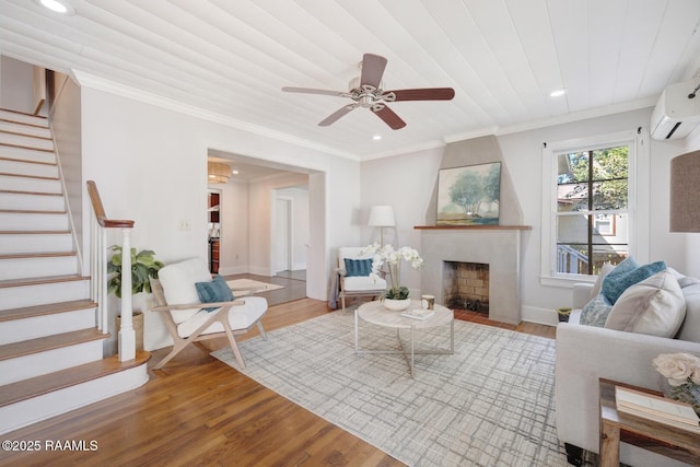 living area with stairs, light wood finished floors, a fireplace, and crown molding