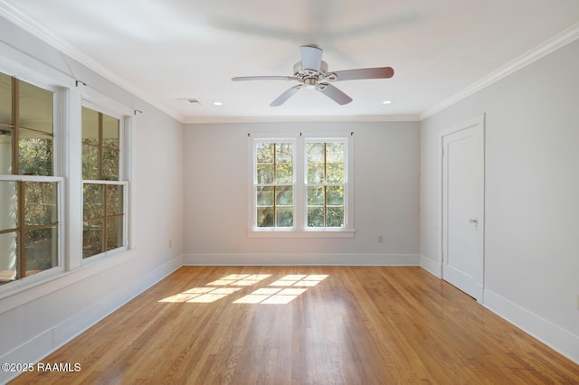 empty room featuring ceiling fan, visible vents, baseboards, light wood-type flooring, and crown molding