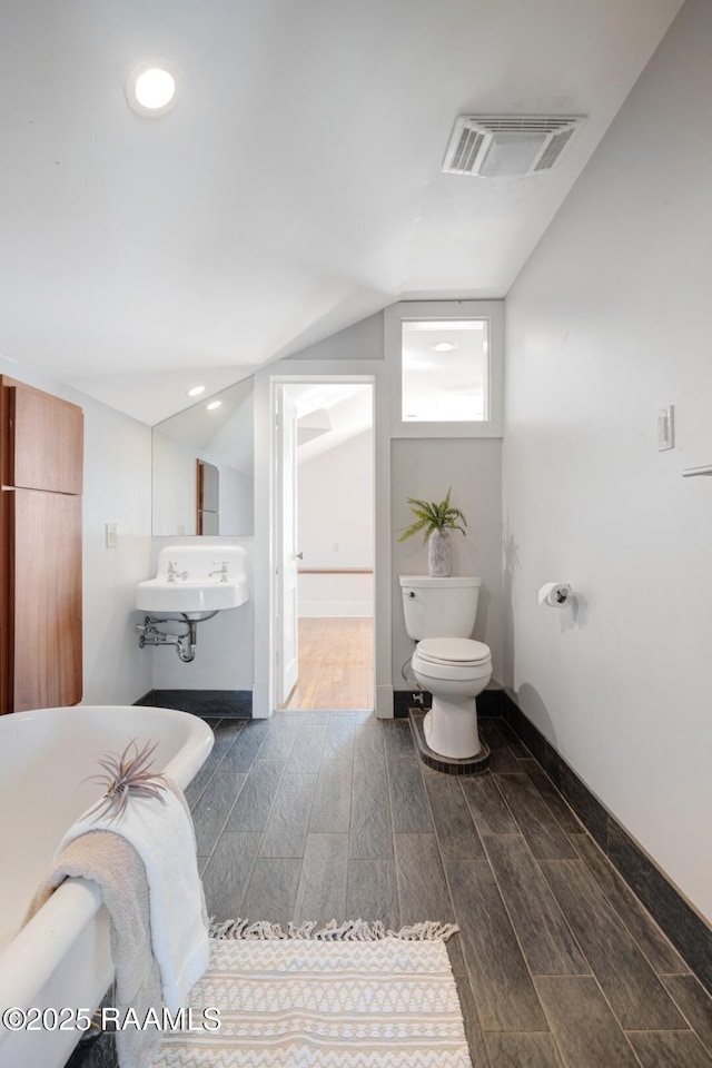 bathroom featuring visible vents, toilet, vaulted ceiling, wood finish floors, and recessed lighting