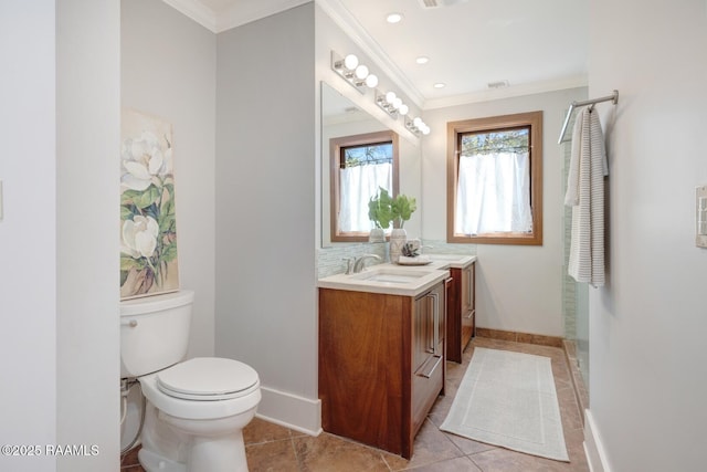 bathroom with double vanity, toilet, ornamental molding, a sink, and baseboards