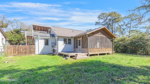 back of property with a sunroom, stairway, fence, a yard, and central AC